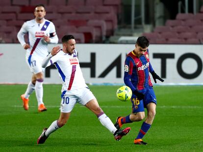 Edu Expósito trata de arrebatarle el balón a Pedri en el Camp Nou.