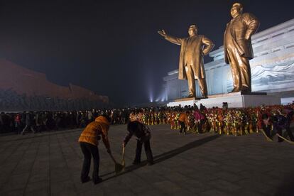 Coreanos del norte presentan sus respetos, en la base de las estatuas de los líderes Kim Il Sung, y Kim Jong Il el lunes, 16 de diciembre de 2013, la víspera del segundo aniversario de la muerte de Kim Jong Il.