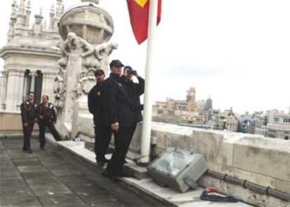 Miembros de la Policía vigilan desde el tejado del Palacio de Comunicaciones la Plaza de Cibeles.