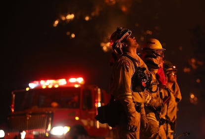 Um grupo de bombeiros observa as chamas em Rocky, próximo a Clearlake.