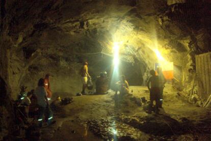Varios mineros escuchan a un miembro del equipo de rescate una vez que comenzó el salvamento.