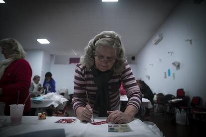 Una mujer pinta un delantal para colocar en su ventana el día 8 de marzo y visibilizar la huelga. Con plantillas, estampa el símbolo feminista y el lema 'huelga feminista'.