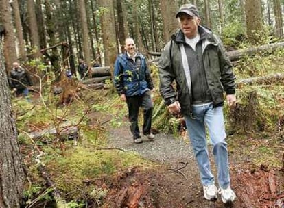 El candidato republicano John McCain pasea, seguido por el gestor de programas culturales Ralph Naess, por un bosque en la zona de Cedar River.