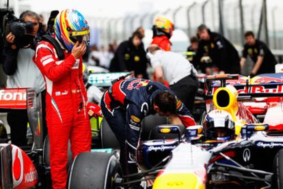 Alonso mira el coche de Vettel tras conseguir la<i> pole</i> el piloto de Red Bull.