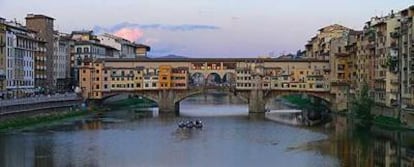 El río Arno con el Ponte Vecchio, un puente de tres arcos por encima del cual se suceden tiendas y el corredor de Vasari (de 1565).