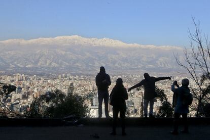 Un grupo de turistas toman fotografías en la colina de San Cristóbal en Santiago de chile, el 16 de julio de 2017. Chile fue cubierta el pasado fin de semana por la mayor nevada en décadas.