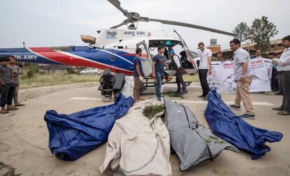 Policías nepalís y miembros de los servicios de rescate, con cuatro de los cadáveres rescatados, en Katmandú.