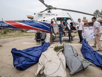 Policías nepalís y miembros de los servicios de rescate, con cuatro de los cadáveres rescatados, en Katmandú.