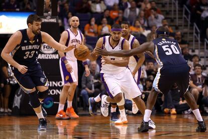 Marc Gasol, de los Grizzlies, trata de frenar el avance de Dudley, de los Suns