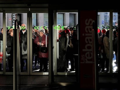 Un grupo de personas aguarda a la apertura de puertas de una tienda en Madrid.