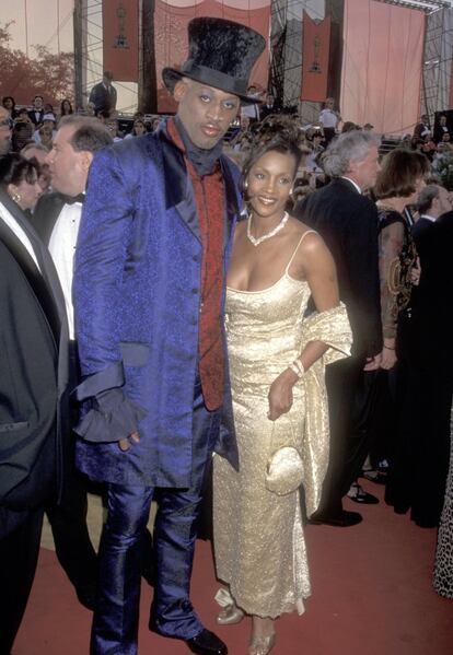 Dennis Rodman y la actriz Vivica A. Fox. En la gala de 1997. Rodman será recordado como uno de los asistentes peor vestidos de la historia de los Oscar. Su excéntrico traje se llevó las peores críticas. 