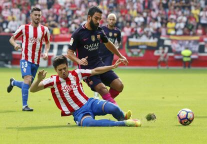 El defensa del Sporting de Gijón Jorge Meré (i) disputa un balón con el delantero turco del FC Barcelona Arda Turan (d).