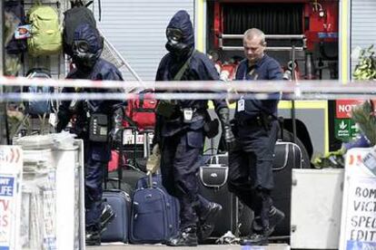 Varios policías con máscaras antigás entran en la estación de metro londinense de Warren Street.