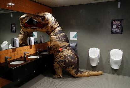 Un visitante con un disfraz de T-Rex en los lavabos de la Comic Con de Londres.