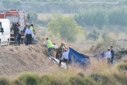 Los bomberos trasladan los cuerpos de los fallecidos. 