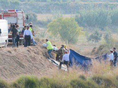 Los bomberos trasladan los cuerpos de los fallecidos. 