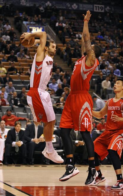 José Calderón salta para realizar un pase por encima de Marcus Morris.