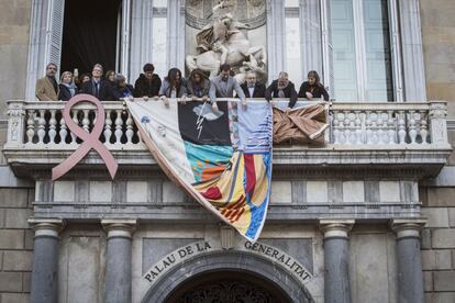 El conseller de Salud, Antoni Comín (4 por la derecha), cuelga el tapiz memorial del SIDA en el Palau de la Generalitat con motivo de la celebración del Día Mundial del Sida, en un acto simultáneo con el Ayuntamiento de Barcelona, ambos situados en la plaza de Sant Jaume.