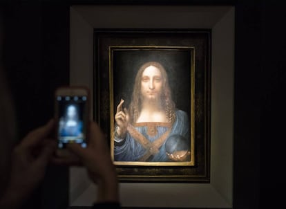 Un visitante toma una foto del Salvador Mundi en Christie&#039;s.