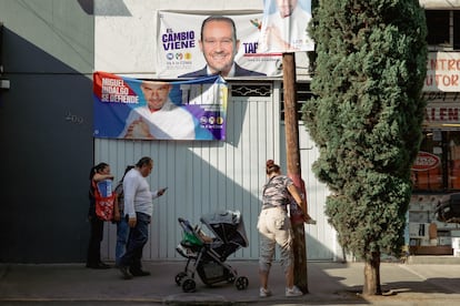 Una mujer pega coloca un cartel en la alcaldía Miguel Hidalgo.