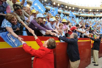 Rita Barberá, Francisco Camps y Mariano Rajoy saludan a los simpatizantes del PP, ayer en la plaza de toros de Valencia.