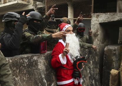 Las fuerzas de seguridad iraquíes junto a un manifestante disfrazado de Santa Claus durante una protesta en Bagdad (Irak), el 6 de diciembre.