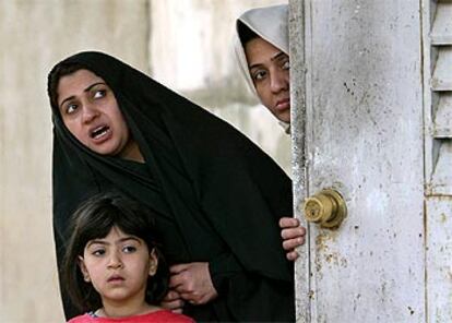 Dos mujeres iraques miran a las fuerzas estadounidenses que buscan armas de destruccin masiva, ayer en el barrio de Kazemiya en Bagdad.