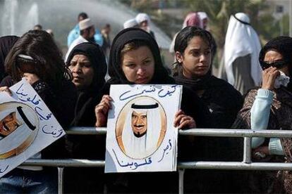 Mujeres muestran retratos del fallecido emir Jaber al Ahmed al Sabah durante su funeral en Kuwait.