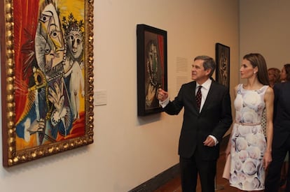 Doña Letizia atiende a las explicaciones del comisario de la exposición, Javier Barón, sobre la obra de Picasso "Mosquetero con espada y amorcillo".