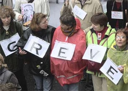 Cinco mujeres forman la palabra <i>grève</i> (huelga en francés) durante la protesta de ayer.