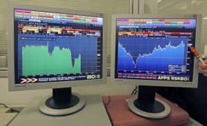Pantalla que muestra la evolución de la prima de riesgo (i) y el principal indicador de la bolsa española, el IBEX 35 (d). EFE/Archivo