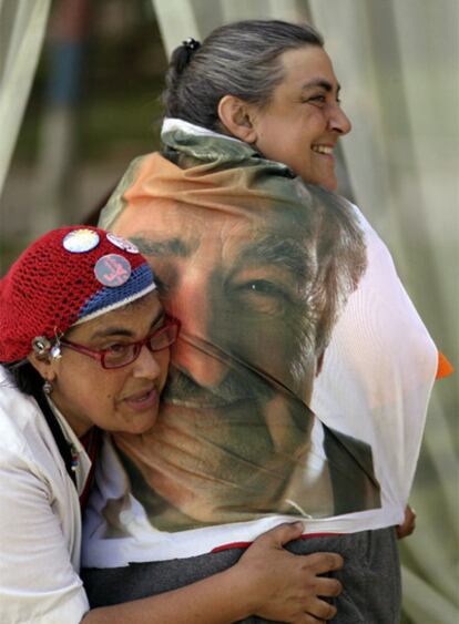 Dos mujeres celebran la victoria de Mujica con una bandera con su foto.