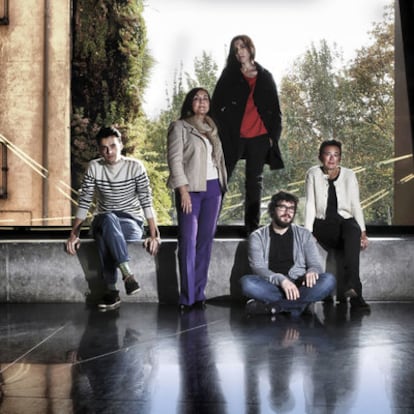 Cinco comisarios posan en el edificio de CaixaForum Madrid.