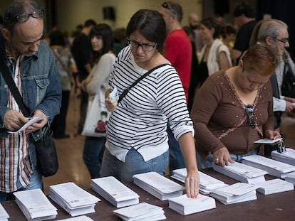 Electores cogen papeletas en una jornada electoral.