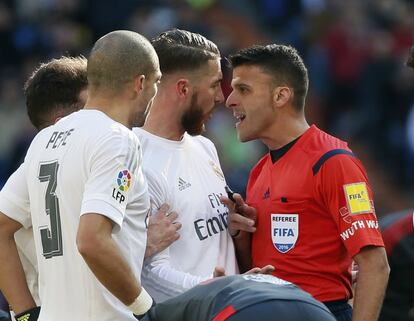 El defensa del Real Madrid Sergio Ramos (c) ante el árbitro Jesús Gil Manzano (d).