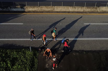 Vista aérea que muestra a migrantes caminando al lado de una carretera en Cuntalapa, México.