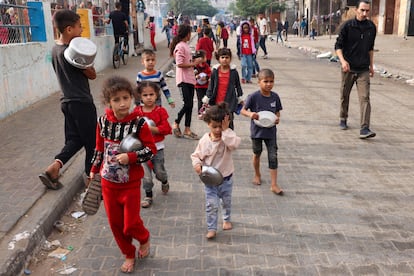 Niños palestinos desplazados se dirigen a desayunar en un campo de refugiados en Rafah, al sur de la Franja, este domingo.