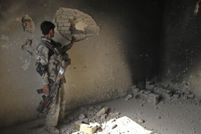 Un soldado afgano comprueba la pared de uno de los edificios oficiales atacado por los talibanes en Kandahar.