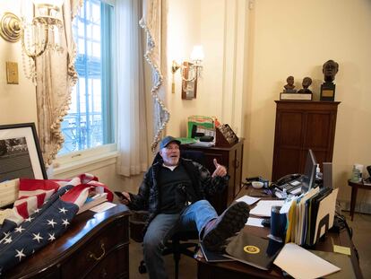 Un manifestante con los pies encima de la mesa de la presidenta de la Cámara de los Representantes, en el Capitolio, en Washington (EE UU).