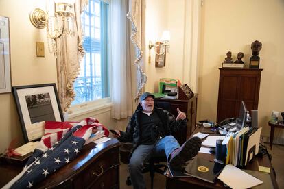 Un manifestante con los pies encima de la mesa de la presidenta de la Cámara de los Representantes, en el Capitolio, en Washington (EE UU).