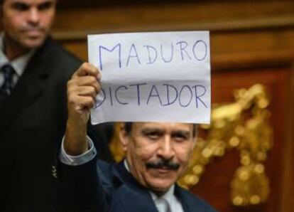 A Venezuelan opposition deputy holds up a sing reading " Maduro dictator" during an extraordinary session of the National Assembly on Sunday.