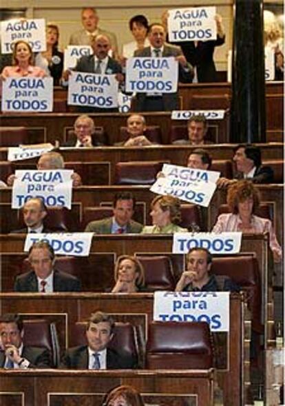 Diputados del PP en el Congreso muestran los carteles del agua.