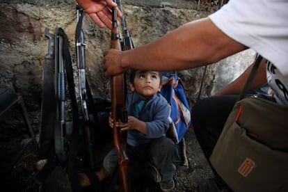 Un ni&ntilde;o mira a su padre, un autodefensa, en Tanc&iacute;taro.