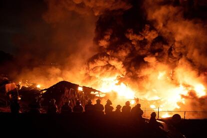 Los bomberos extinguen un incendio en un almacén de cubiertos plásticos, en Manila, el 22 de marzo de 2019.