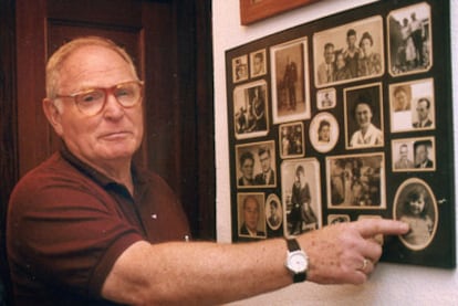 David Story frente a las fotos de su familia, exterminada por los nazis. Solo sobrevivieron él y su prima, a la que señala.