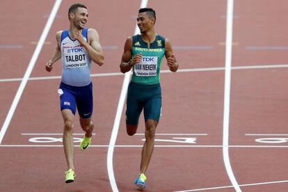 Van Niekerk, a la derecha, charla con el británico Daniel Talbot mientras ambos disputan la serie de 200m.