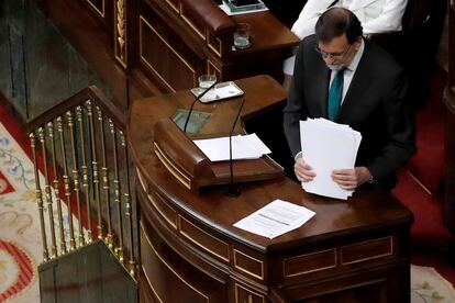 El presidente del Gobierno Mariano Rajoy recoge sus papeles después de su intervención.