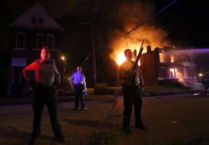 La policía hace guardia junto a un edificio que fue incendiado durante una protesta en Saint Louis, Misuri (EE UU).