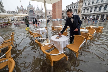 Un camarero prepara unas mesas en la plaza de San Marcos, este sábado. En el centro de Venecia, el sistema de diques MOSE logró limitar la subida del agua a un pico de 62 centímetros.
