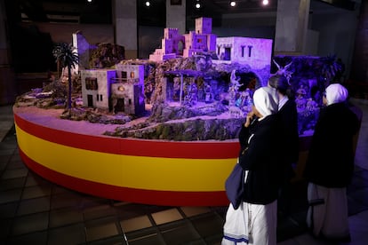 Unos visitantes observan el tradicional Beln municipal, instalado en el Palacio de Cibeles.